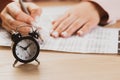 Alarm clock with time running out. Students hands to take exams, write examination room with pencil holding on optical form of Royalty Free Stock Photo