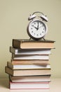 alarm clock top stacked books wooden desk. High quality photo Royalty Free Stock Photo