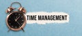 Alarm clock and torn paper revealing the words TIME MANAGEMENT Royalty Free Stock Photo