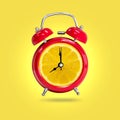 Alarm clock twin Bell-type red with fresh yellow lemon background