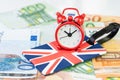 Alarm clock on Union jack, United Kingdom national flag luggage label on Euro banknotes using as countdown on Brexit England Royalty Free Stock Photo