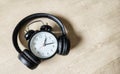 alarm clock using headphones on a brown background