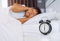 Alarm clock wake up in morning and senior woman close her ears