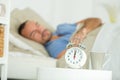 alarm clock waking sleeping man in bed