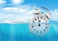 Alarm clock in water, waste of time concept Royalty Free Stock Photo