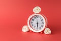 Alarm clock with white rosebuds on a red background