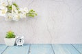The Alarm clock on wood floor and cement wall with white color orchid decorate, empty room for background Royalty Free Stock Photo