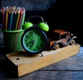 Wooden school pencil case, alarm clock, color pencils, wooden typewriter on an old wooden table. Royalty Free Stock Photo