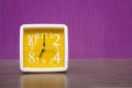 Alarm clock on a wooden table in front of wall Royalty Free Stock Photo