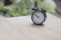 Alarm clock on wooden table in Park. Royalty Free Stock Photo