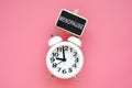 Alarm clock and word menopause on a pink background