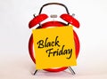 An alarm clock and a yellow note with text Black Friday. Royalty Free Stock Photo
