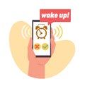 Alarm clock in your cell phone gives you wake up call. Hand hold smartphone with awakening timer with bell on device