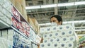 Alarmed female wears medical mask against coronavirus while buying tissues or toilet papers- health, safety and pandemic