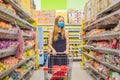 Alarmed female wears medical mask against coronavirus while grocery shopping in supermarket or store- health, safety and Royalty Free Stock Photo