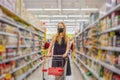 Alarmed female wears medical mask against coronavirus while grocery shopping in supermarket or store- health, safety and Royalty Free Stock Photo