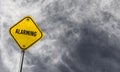 Alarming - yellow sign with cloudy background