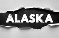 ALASKA text uncovered through torn paper effect, distressed bold typography on textured surface, artistic visual concept of state Royalty Free Stock Photo
