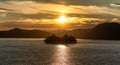 Alaska, USA - June 22 , 2018: Celebrity Infinity sailing at sunset in one of the Alaskan Fjords. Beautiful orange sky, sun setting