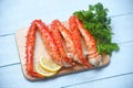 Alaskan King Crab Legs Cooked on wooden cutting board with lemon parsley - red crab hokkaido seafood served table Royalty Free Stock Photo