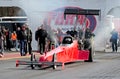 A dragster speeding up in quarter mile race with nitro burning