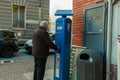 Old man with hearing aid, get the ticket for paid car parking in Italy. Royalty Free Stock Photo