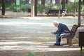 Albacete, Spain, January 18, 2020: Senior gentleman seated on a wooden bench reading a newspaper in Abelardo Sanchez park