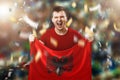 Albanian fan, a fan of a man holding the national flag of Albania in his hands. Soccer fan in the stadium. Mixed media Royalty Free Stock Photo