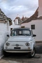 Italy. Traditional white washed trulli house with white Fiat vintage cinquecento 500 car parked in front, in Alberobello Puglia Royalty Free Stock Photo