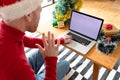 Albino african american man wearing santa hat making video call on laptop with copy space