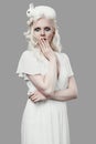 Albino blond girl in elegant dress posing with cute little rabbit Royalty Free Stock Photo