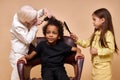 Albino child girl combing curly hair of africanamerican boy isolated