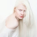 Albino female with white pure skin and white hair. Photo face on a light background. Portrait of the head. Blonde girl