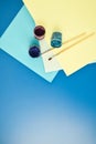 Album pages and paints gouache, brush on a blue background, office supplies, copy space Royalty Free Stock Photo