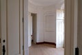 Elegant empty round room with wooden floors and tall white walls and large French Doors