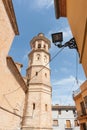 Alcalali church spire rising through narrow typically historic Mediterranean village street, Spain Royalty Free Stock Photo