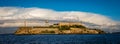 Alcatraz Island with grand white clouds behind the old buildings and water tower Royalty Free Stock Photo