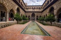 Alcazar palace mudejar inner garden decorated with trees and columns in Seville, Spain