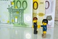 Alcobendas, Spain - May 14, 2018: Handshake for an agreement on bills background, Lego minifigures are manufactured by The Lego