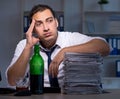 Alcohol addicted businessman working late in the office