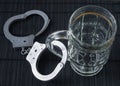 Alcohol addiction. Handcuffs and a glass for beer. Symbolic image of alcoholism.