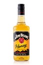 Alcohol bottle - Jim Beam Honey whiskey over a plain white background with reflection.