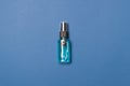 Alcohol clean hand sanitizer in bottle on blue colored paper background