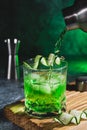 Alcohol cocktail with cucumber pouring from shaker in whiskey glass with ice cubes. Summer coctail Royalty Free Stock Photo