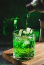 Alcohol cocktail with cucumber pouring from shaker in whiskey glass with ice cubes. Summer coctail Royalty Free Stock Photo