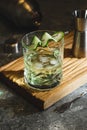 Alcohol cocktail with cucumber in whiskey glass with ice cubes. Summer spirit drink and shaker Royalty Free Stock Photo