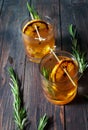 Alcohol cocktail with lemon, ice and smoking rosemary on dark table Royalty Free Stock Photo