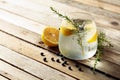 Alcohol drink gin tonic cocktail with lemon, juniper branch,  and ice on rustic wooden table Royalty Free Stock Photo