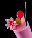 Alcohol drink, pink cocktail with flowers, strows, isolated black Royalty Free Stock Photo