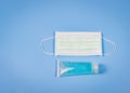 Hand Sanitizerand and Disposable Hygienic Mask on blue background . protection against pm2.5 and COVID-19 concept